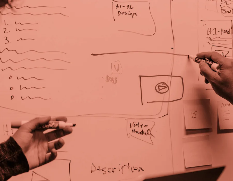 Two people sketching a plan on a whiteboard, the working session behind the Pike & Co rebrand