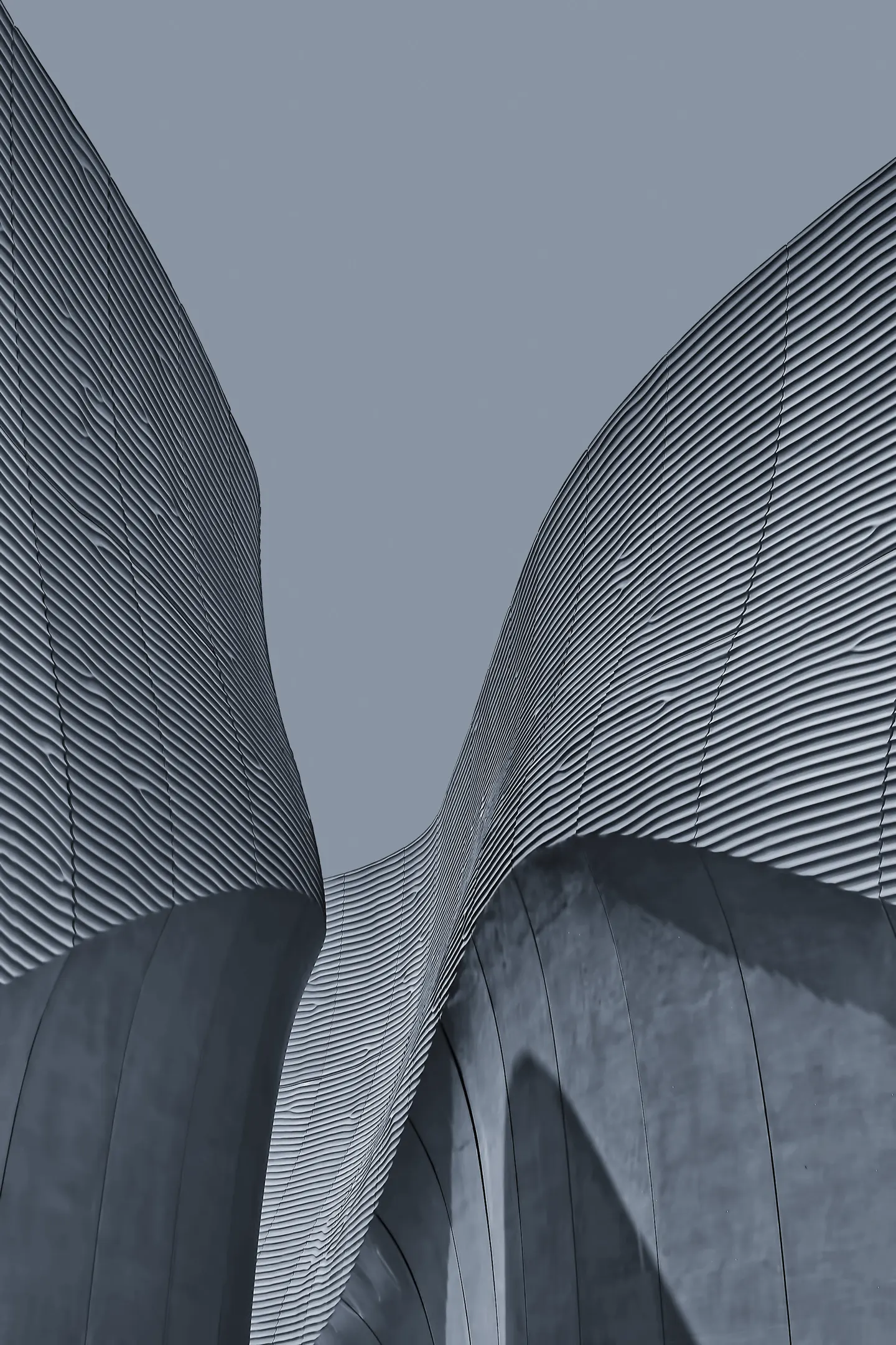 Weathering steel facade of the Fenwick Foundry, curving ribbons of corten against the sky