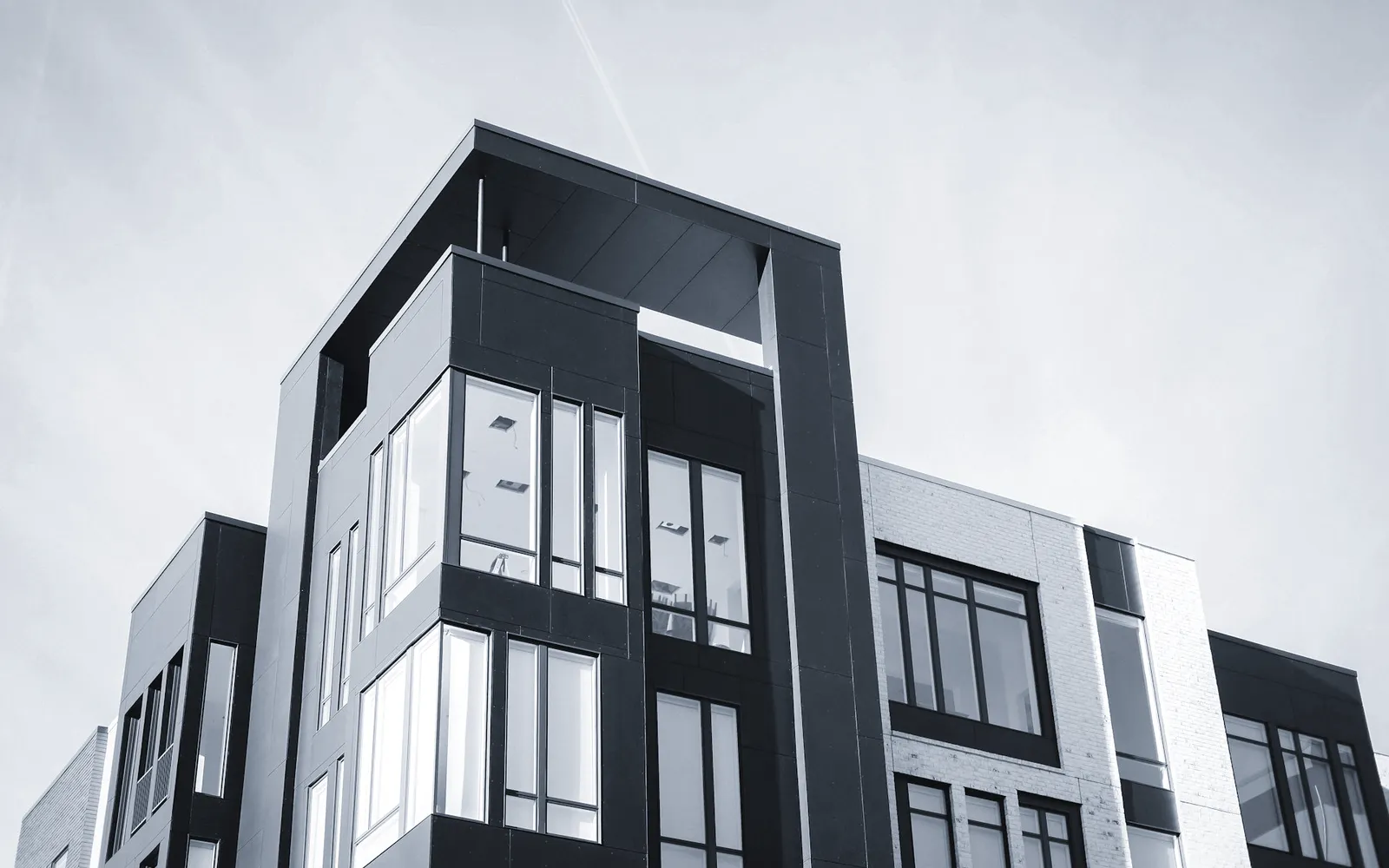 The completed Ledbury Terrace housing scheme, a gridded facade of glazing and dark panels