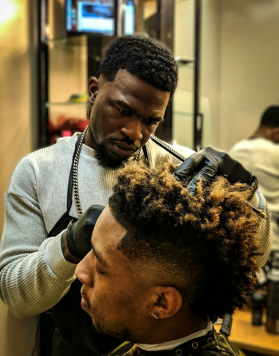 A barber shaping a client's hair with clippers at Quarter