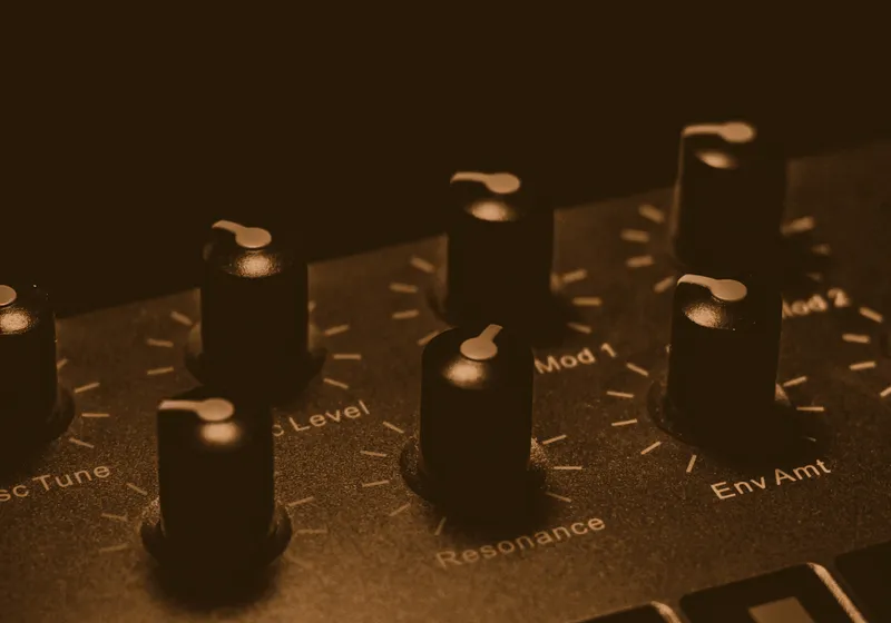 Close detail of synthesiser knobs labelled resonance and envelope amount.