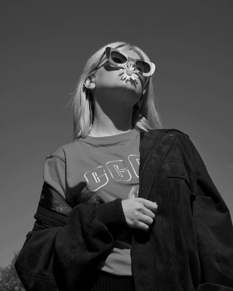 Model in a printed tee with a jacket pulled off the shoulders