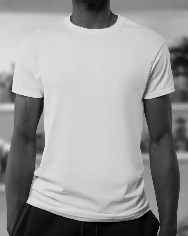 Heavy white tee worn against a plain wall