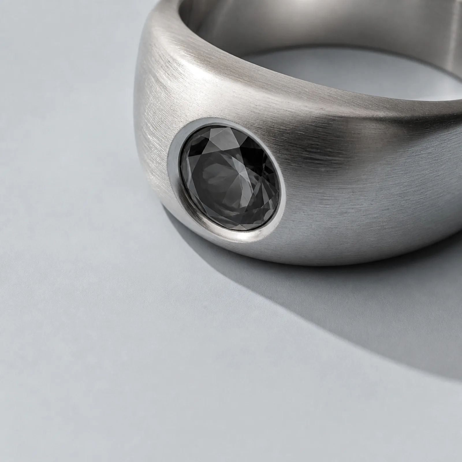 A platinum solitaire ring at macro scale, its stone holding a single hard light.