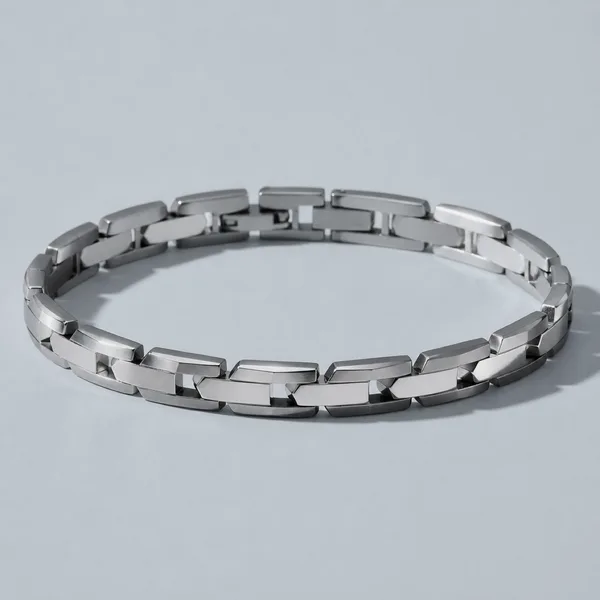 A flat linked platinum bracelet lying in an open curve.