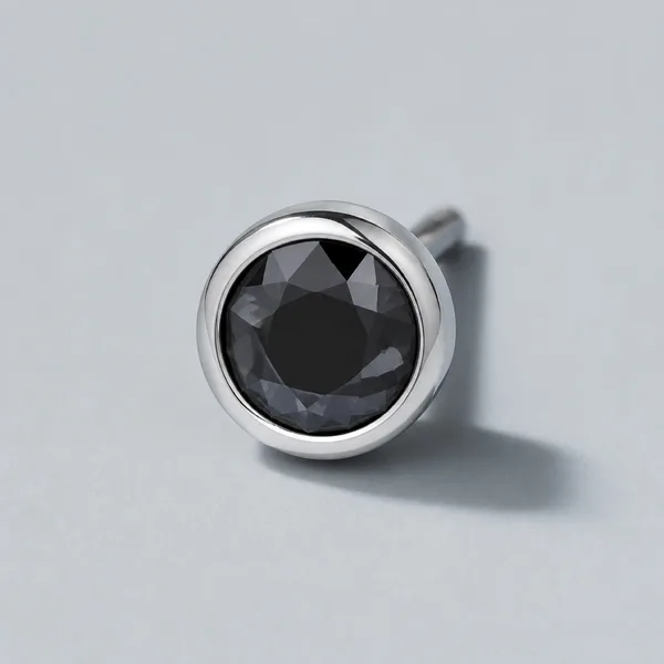 A platinum ring with a dark rose cut stone set flush into a bezel.