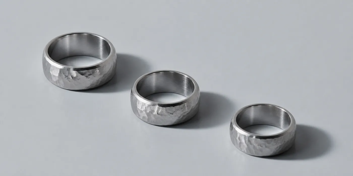 Three hammered platinum bands of different widths, set out in a row.