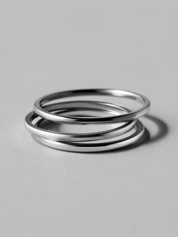 Three slim platinum stacking rings resting together.