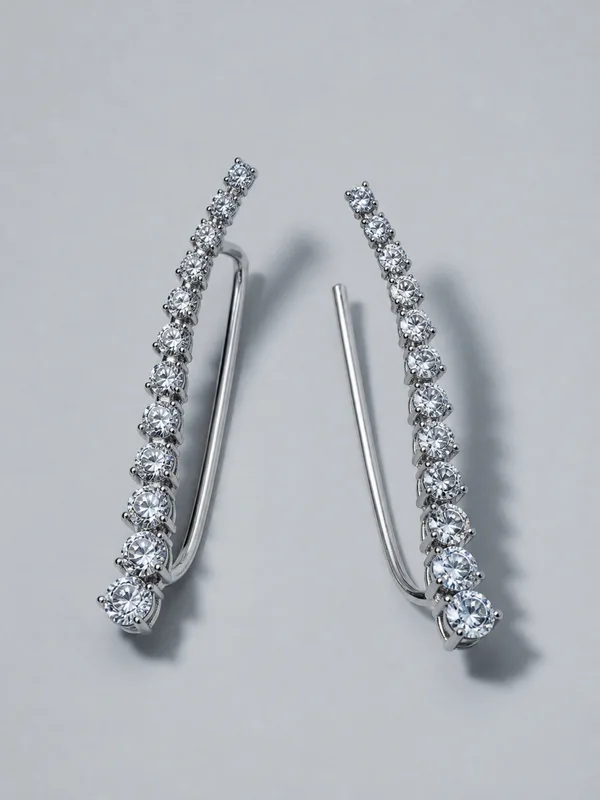 A pair of long platinum ear climbers set with a line of small stones.