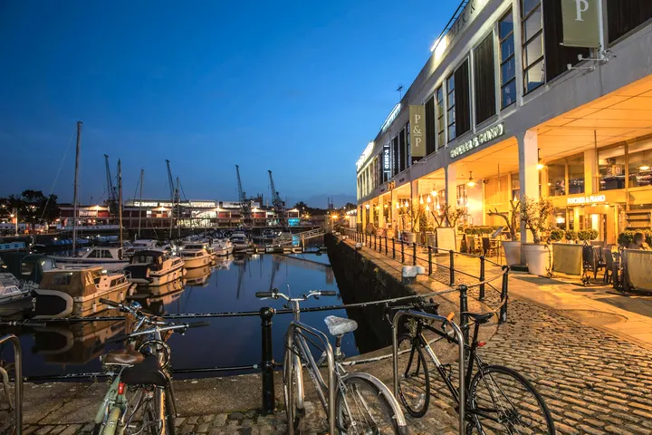 The waterside at Temple Quay, masts and lit buildings