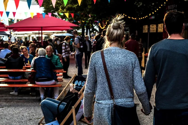 Bunting strung over a busy food festival at dusk