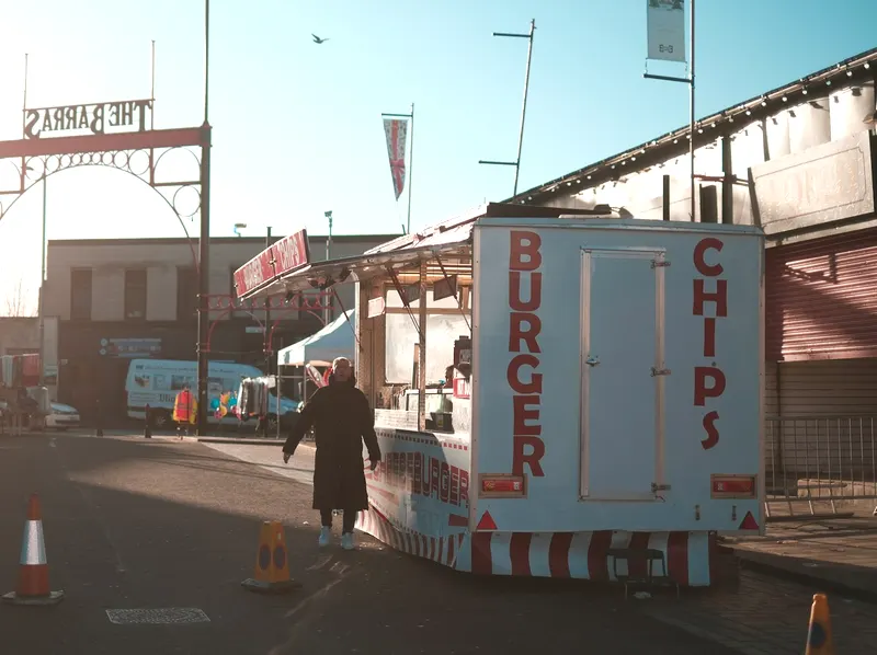 A burger van glowing in low evening sun at a street market