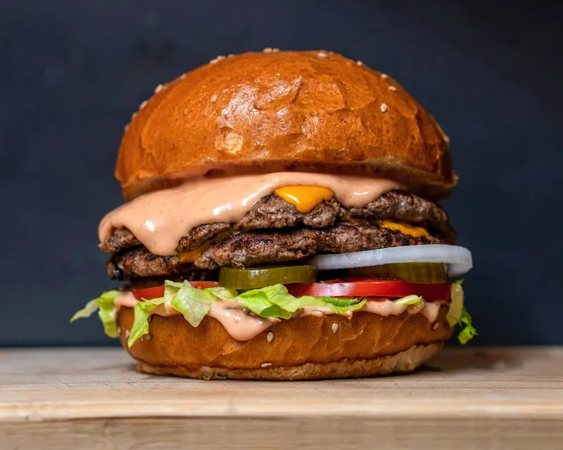 A double smash burger with melted cheese, pickles and wagon sauce