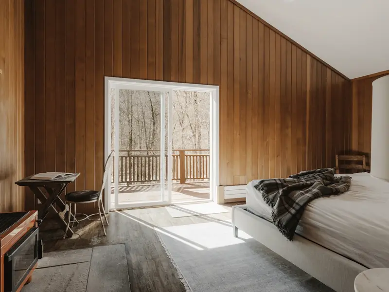 The double bedroom, timber lined, with the door open to the deck