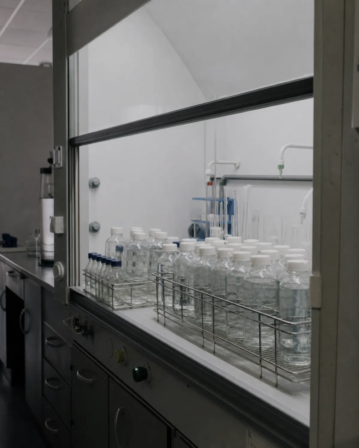 A laboratory bench at Kestrel Analytical, racks of sample bottles under a fume hood.