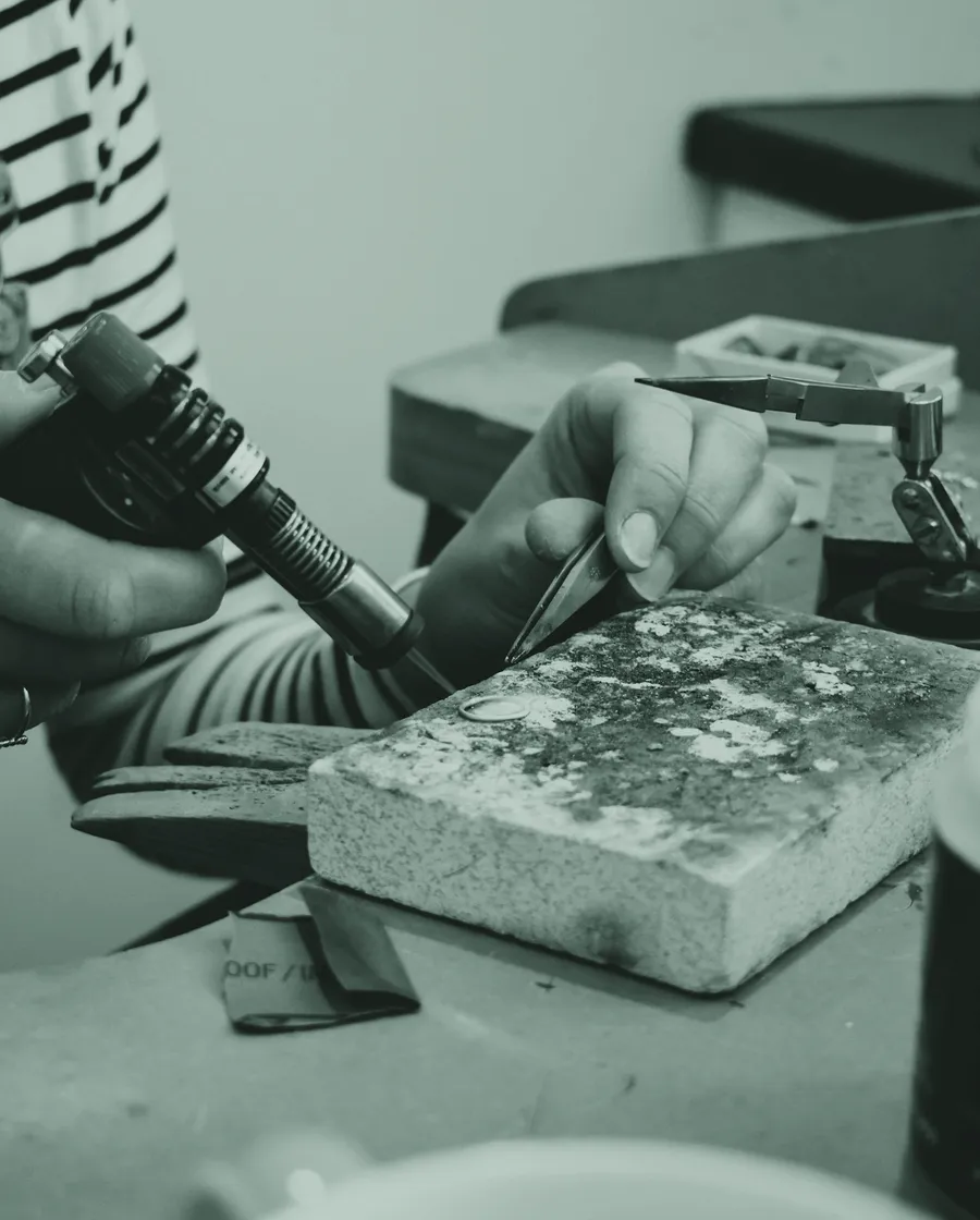 A maker soldering at a workbench.