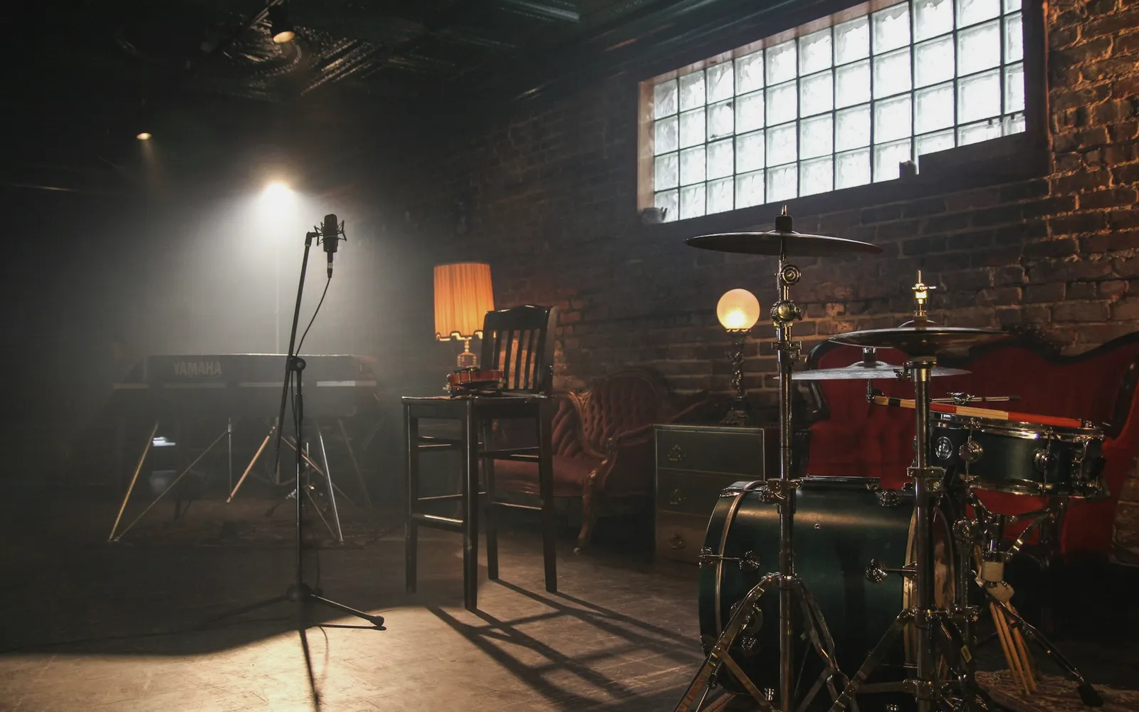 Bare industrial hall with a stage rig lit by a single window