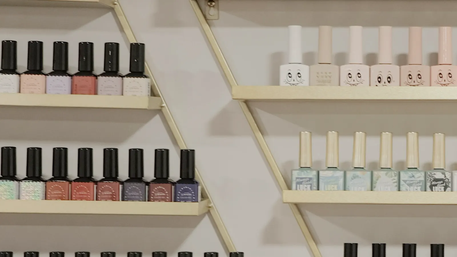 Shelves of gel polish bottles along the studio wall