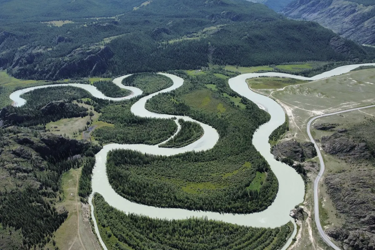 A river winding in tight loops through a green valley