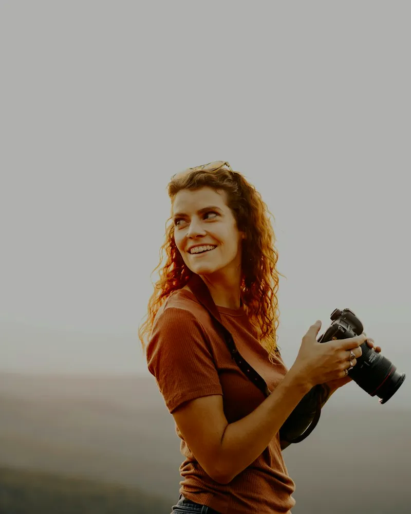 Ines Marchetti holding a camera on a misty headland