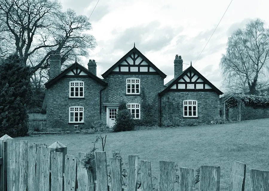 A gabled brick and timber lodge standing on open grass