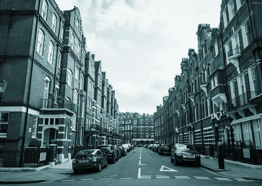 A street of tall red brick mansion blocks receding into the distance