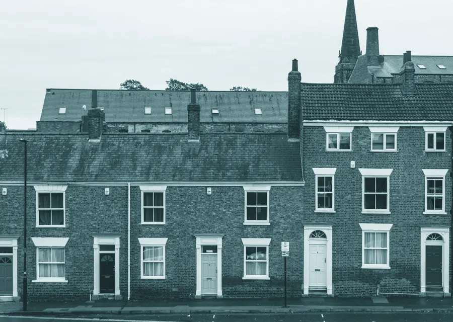 A row of pale stone terraced houses under a low grey sky