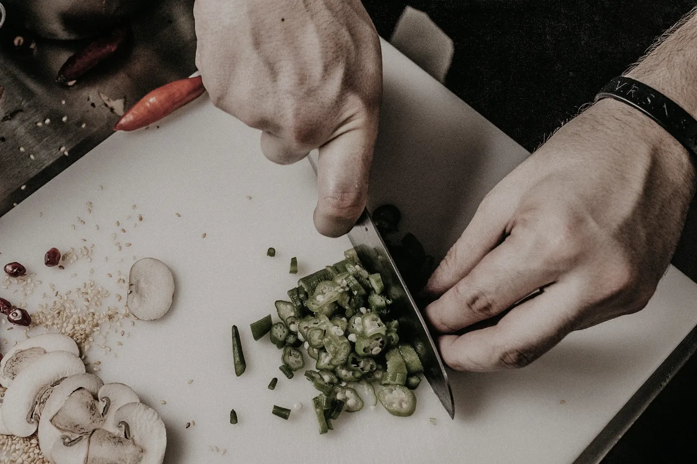 A chef finely chopping herbs on a wooden board