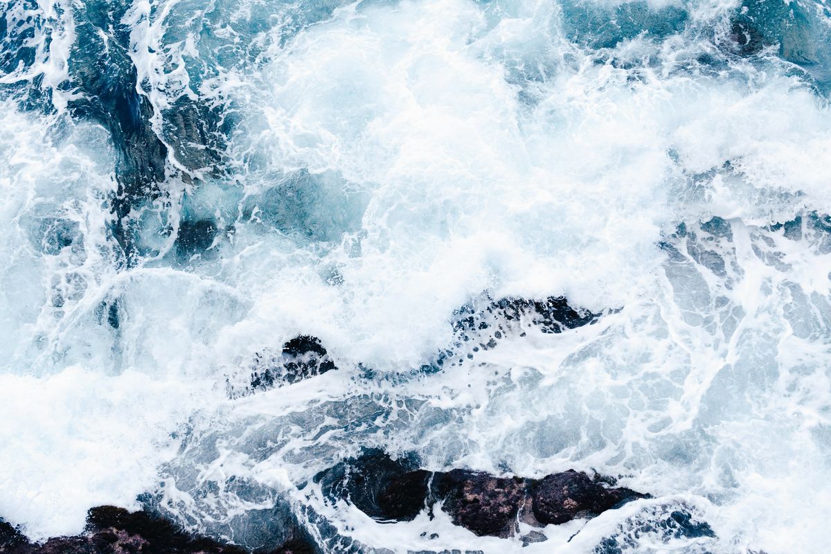 Ocean breaking over dark rocks