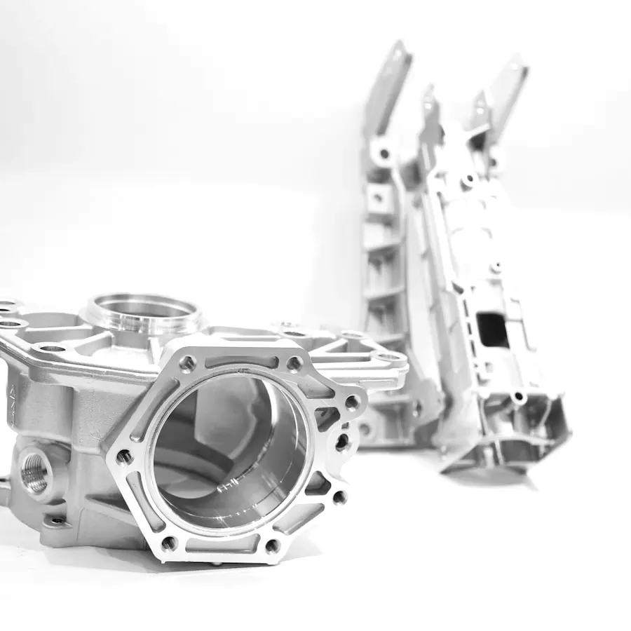 Cast and machined aluminium pump housings photographed against white.